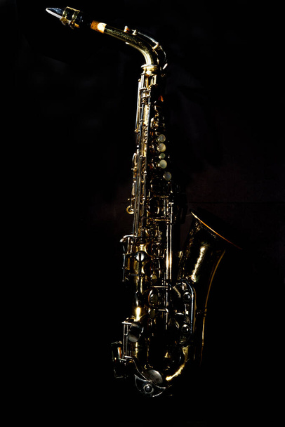 Antiguo saxofón de jazz alto desgastado abollado sobre fondo liso - Foto, imagen