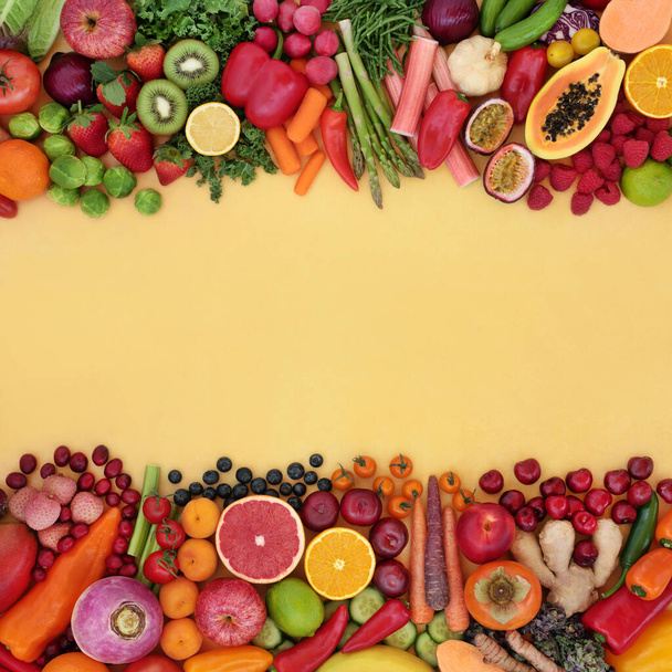Antioxidant health food to fight free radicals with fruit & vegetable high in fibre, anthocyanins, lycopenes, protein, vitamins, minerals & carotenoids. Healthy lifestyle concept. Flat lay border on yellow. - Photo, Image