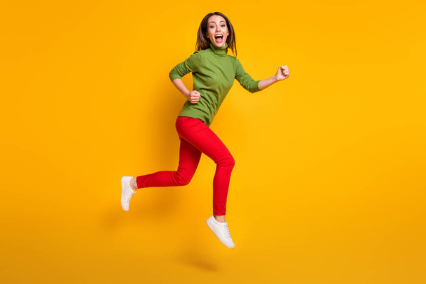 Full size profile photo of crazy lady jump up rush wear casual green pullover shoes red trousers isolated yellow color background - Foto, immagini