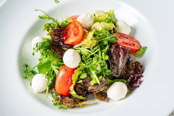 fresh salad with mozzarella and vegetables - Foto, afbeelding