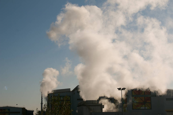 Fumo dal camino della fabbrica chimica su sfondo cielo nuvoloso. Tema ecologia. - Foto, immagini