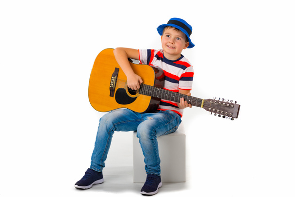 Um garoto toca guitarra em um fundo branco no estúdio. - Foto, Imagem
