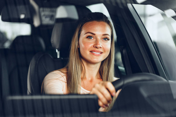 Happy woman driving a car and smiling - Foto, Imagen