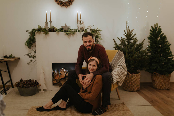 Merry Christmas and Happy Holidays! Pretty family spend good time together in front of the fireplace. - Foto, afbeelding