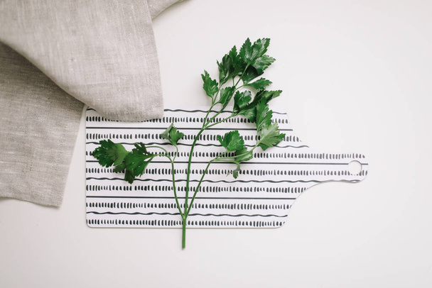 Top view of fresh parsley on cutting board. Fresh greens on white table. copy space. Mock up for blog or recipe, flat lay - Fotoğraf, Görsel