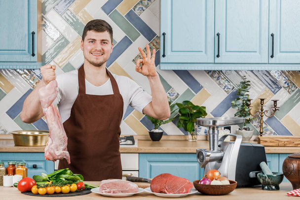 Un chef masculino tiene carne de conejo en la cocina. El concepto de cocinar - Foto, Imagen