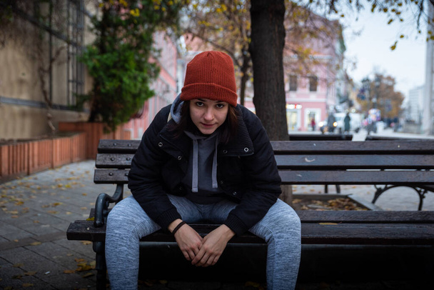 Very young homeless teenage girl sitting outdoor on the city street of the city feeling angry and abandoned on the cold winter day real people - Foto, immagini