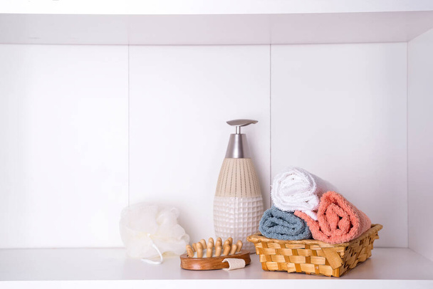 toallas en una bandeja de madera con palillos aromáticos, velas, conchas marinas, paños de masaje y una botella con un dispensador - Foto, imagen