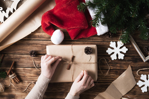 DIY Christmas gifts and packaging of kraft paper on a wooden table.  - Foto, Imagen