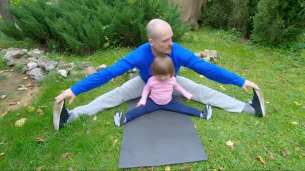 Familie sportactiviteiten in de natuur. Stretching en Pilates in het park - Video