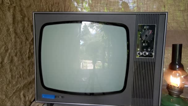 Homem com uma lâmpada de querosene liga uma TV retrô antiga - Filmagem, Vídeo