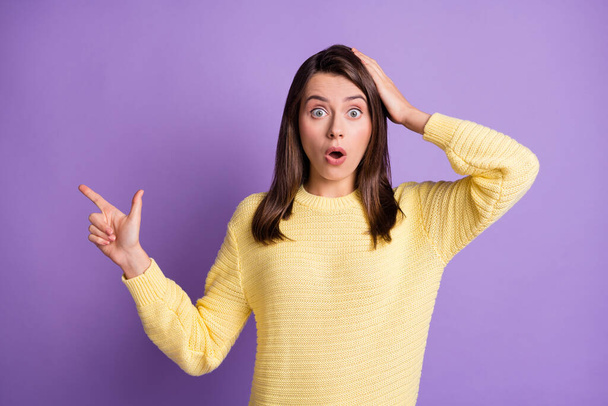 Photo portrait of shocked woman pointing one finger at blank space isolated on vivid purple colored background - 写真・画像