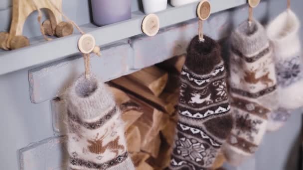 Κοντινό πλάνο γυναικείων χεριών που κρέμονται χριστουγεννιάτικες κάλτσες κοντά στο τζάκι - Πλάνα, βίντεο