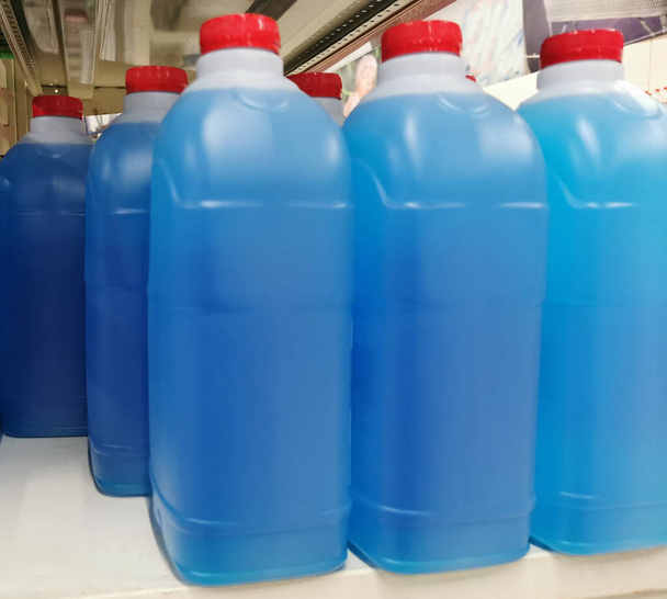 bottles with blue liquid for cleaning on the store shelf - Photo, Image