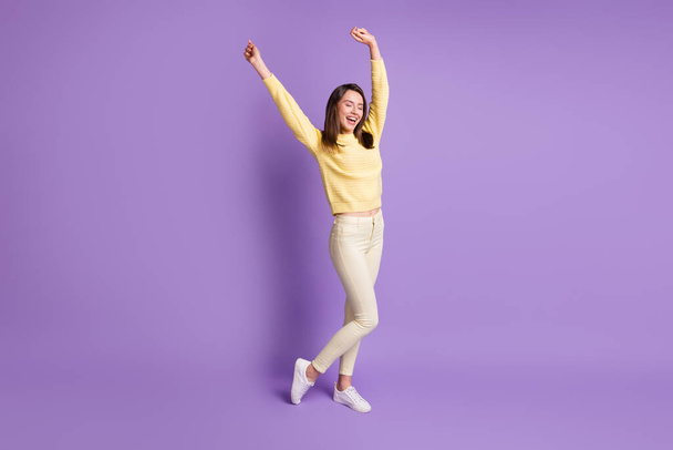 Photo portrait of young girl dancing with hands in air laughing isolated on vivid purple colored background - Fotografie, Obrázek