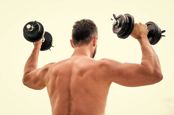 Sport equipment. Bodybuilding sport. Sport lifestyle. Dumbbell exercise gym. Muscular man exercising with dumbbell rear view. Actions speak louder than coaches. Sportsman with strong back and arms - Foto, afbeelding