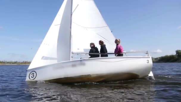 Fehér jacht versenyez a hullámok alatt egy regatta a folyón. Dinamikus felvétel lassított mozgású hatással. - Felvétel, videó