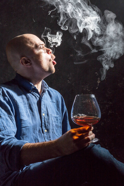 Solid bald man in shirt with glass of whisky and fume - Zdjęcie, obraz
