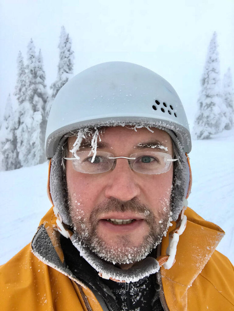 Портрет лыжника-сноубордиста в шлеме с замерзшей бородой и волосами. Большой Белый Курорт. Келоуна. Британская Колумбия. Канада  - Фото, изображение