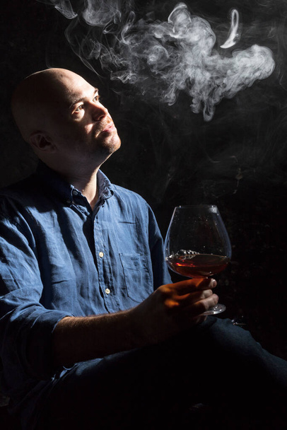 Solid bald man in shirt with glass of whisky and fume studio portrait. - Foto, immagini