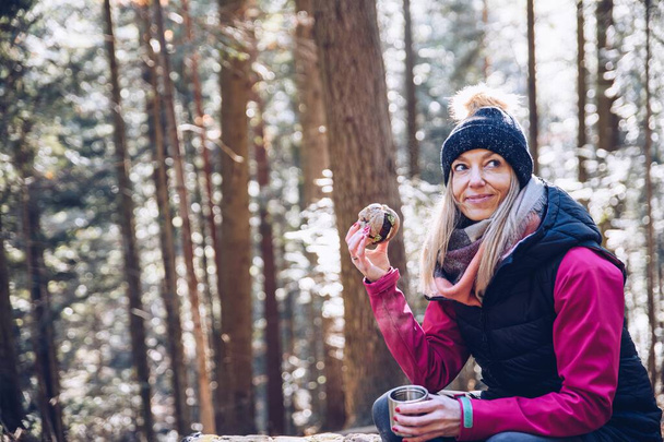 Блондинка посміхається жінка турист робить перерву на гарячий чай і їжу на гірському шляху
. - Фото, зображення