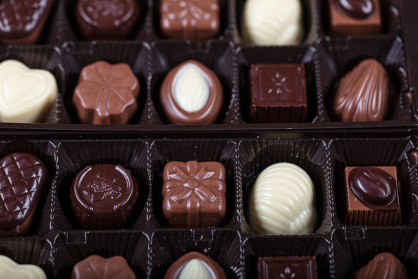 Σοκολάτα στο κουτί. Ειδικά συσκευασμένη σοκολάτα δώρου - φιστίκι, φουντούκι, καρυδιά. - Φωτογραφία, εικόνα