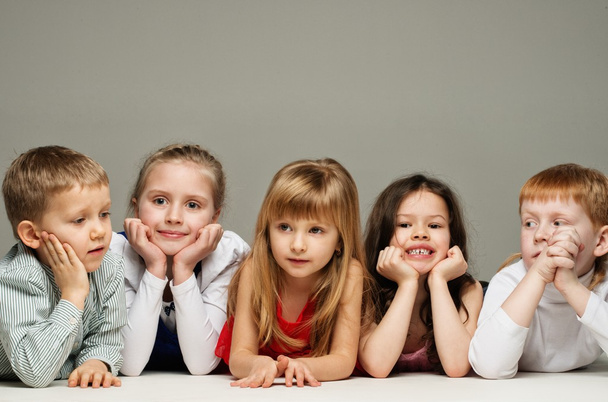 Gruppe von kleinen Kindern in einer Reihe liegen isoliert auf grau - Foto, Bild