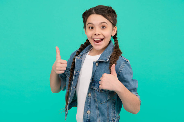 Best version of you. Happy kid give thumbs ups blue background. Little girl smile gesturing thumbs ups. Approval gesture. Hand sign. Hair salon. Trendy style. Fashion trend. Spread your charm - Fotoğraf, Görsel