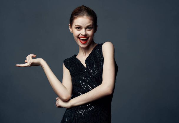 A woman in a black dress gestures with her hands surprise delight emotions. - Fotó, kép