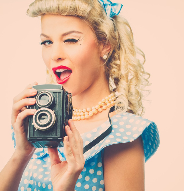 Blond coquette pin up style young woman in blue dress with vintage camera  - Photo, Image