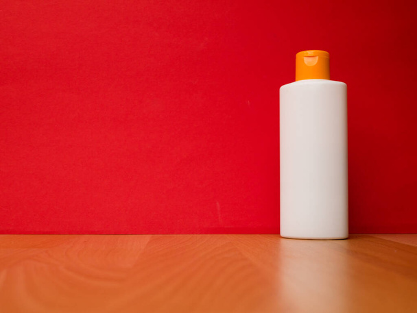 Witte tube fles shampoo, conditioner, mondwater, op een rode achtergrond. - Foto, afbeelding
