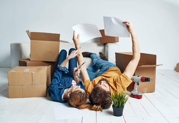 Retrato de hombre y mujer con cajas moviendo planos para el futuro apartamento - Foto, Imagen