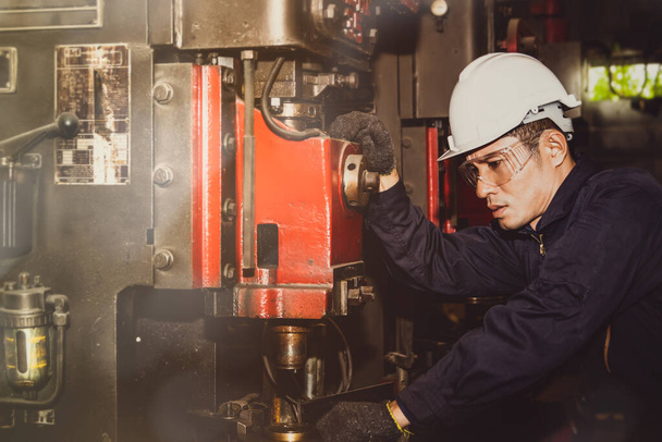 Mannelijke ingenieur houdt toezicht op industrieel werk, inspecteert grote machines voor metaalwerkpompen, inspecteert het werk en de veiligheid serieus, verhoogt de efficiëntie in industriële toepassingen. - Foto, afbeelding