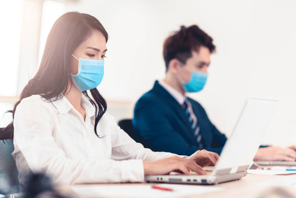 Gente de negocios que usa mascarilla médica mientras trabaja en la oficina - Foto, imagen