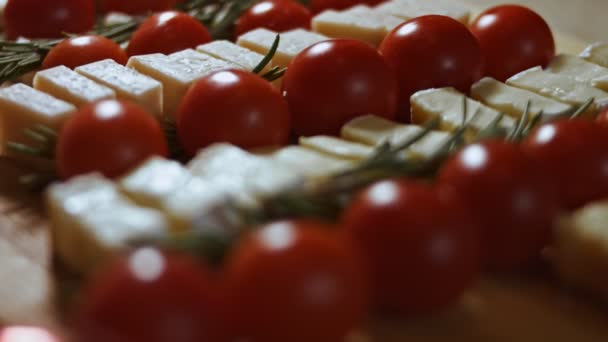 Peynir ve domates düzlüğü. Noel ağacı şeklinde dizilmiş peynir, domates ve rozmarin dilimleri. Noel tatili için yemek. Yavaş çekim, makro görünüm - Video, Çekim