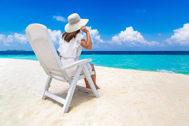 Hermosa mujer relajándose en el solárium en la playa tropical de lujo en un día soleado de verano - Foto, imagen