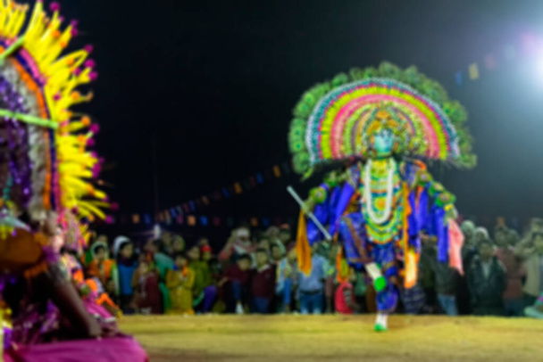 Rozmazaný obraz taneční umělkyně Chhou, která vystupuje jako Bůh Kirshna na festivalu Chhou Dance. Indický kmenový tanec v noci, natočený pod barevným světlem. Purulia, Západní Bengálsko, Indie. - Fotografie, Obrázek