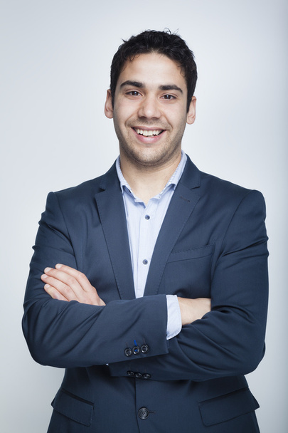 Confident business man smiling on grey background - Фото, зображення