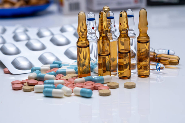 grande número de medicamentos e pílulas são empilhados em uma pilha e deitado em um fundo branco - Foto, Imagem