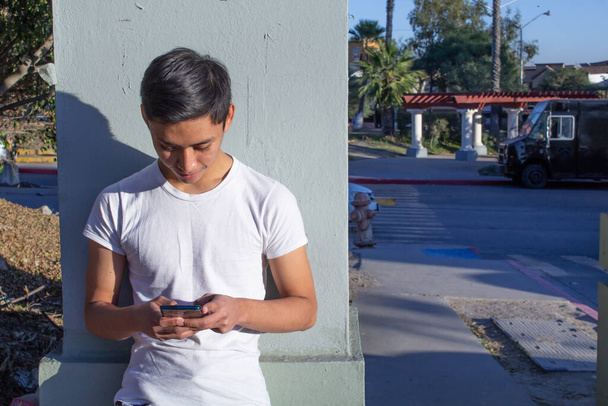 Latinky student pomocí mobilního telefonu na school.Mexico teenager - Fotografie, Obrázek