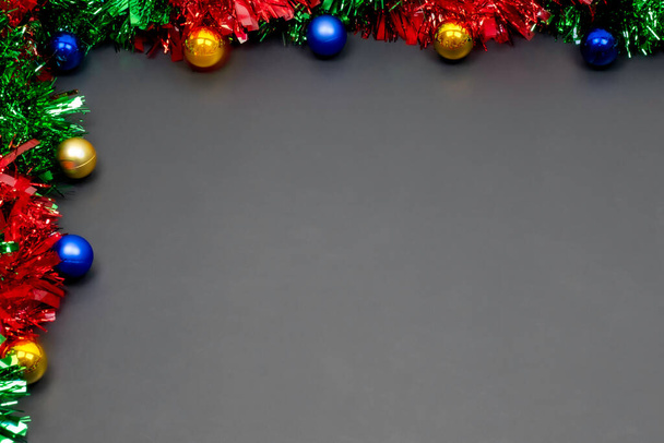 Christmas border template with fir branches, Beautiful red green blue and gold toys and ribbon,on space gray color background, Merry Christmas and Happy New Year. - Photo, Image
