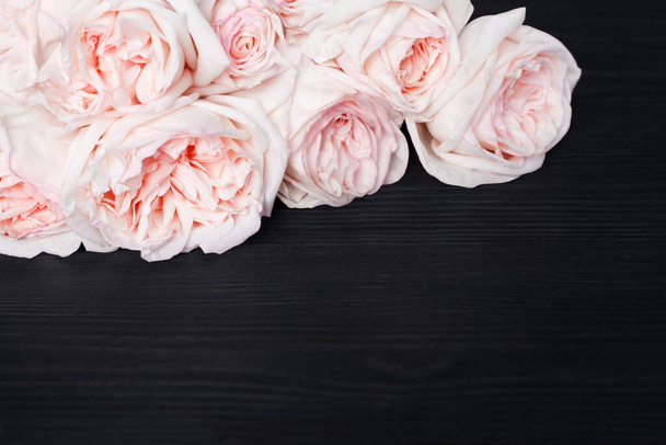 Delicate rose rosa chiaro sfondo in legno nero primo piano, bellissimo bouquet di fiori bianchi e rossi su legno scuro, biglietto di auguri di compleanno, giorno di San Valentino, cornice di nozze, bordo floreale, spazio di copia del testo - Foto, immagini