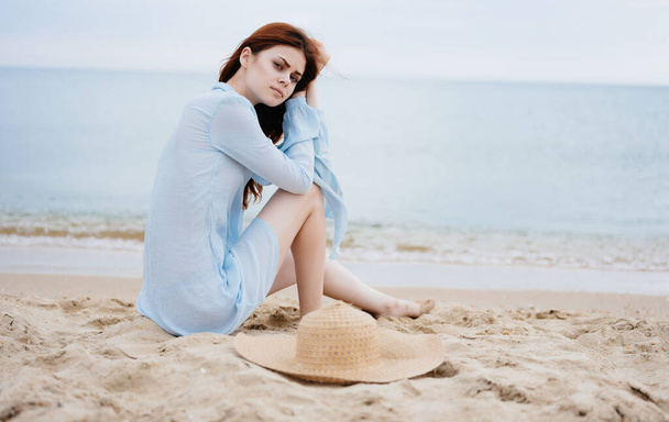 Женщина сидит на песчаном пляже отдых природа свежий воздух - Фото, изображение