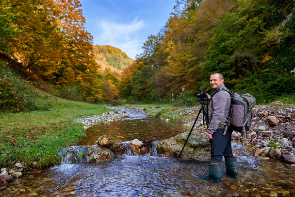 Professional nature photographe with large backpack, camera and tripod - Foto, Imagen