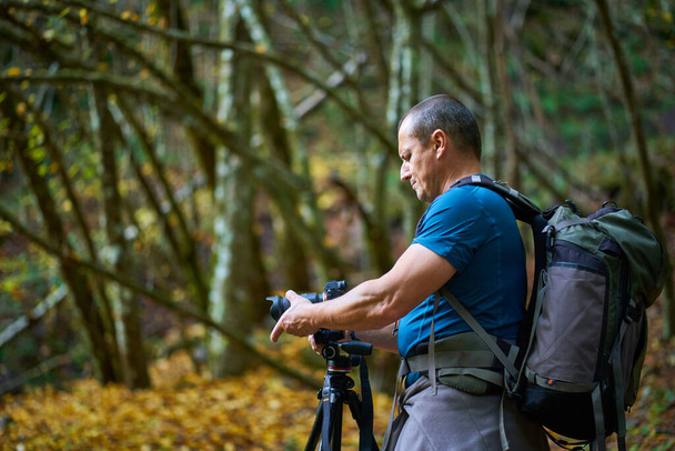 Professional nature photographe with large backpack, camera and tripod - Фото, изображение