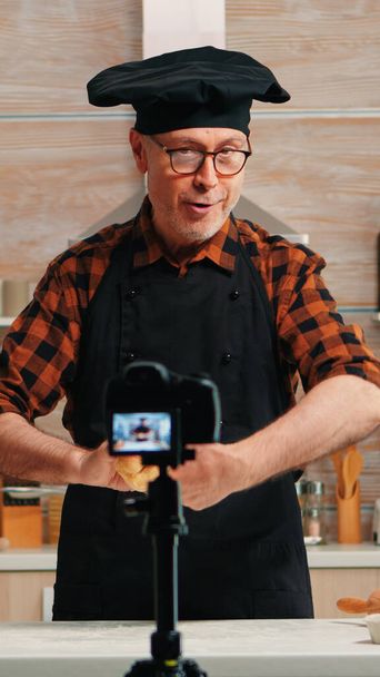 料理ブログのためのコンテンツを作成するシニア男性 - 写真・画像
