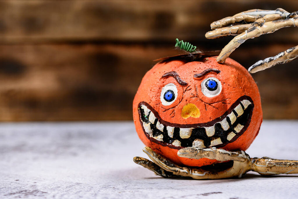 Halloween decoration. Trick or treat in autumn and fall season. Pumpkin face and scary symbol on wood background. - 写真・画像