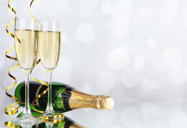 Glasses and bottle of champagne on light background - Фото, зображення