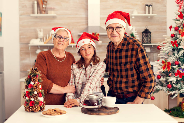 Veselý multigenerační rodina nosí Santa klobouk těší Vánoce - Fotografie, Obrázek