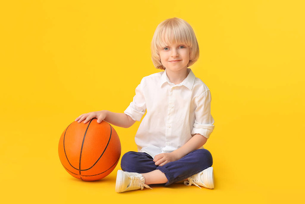 Cute sporty boy with basketball on color background - Foto, afbeelding